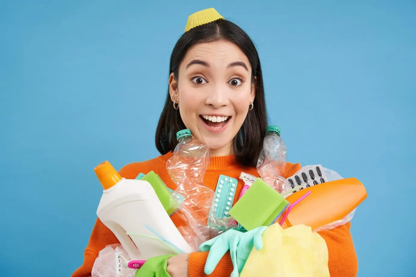 Porträt einer begeisterten koreanischen Frau, die leere Plastikflaschen hält, Müll sortiert, lächelt und schaut.